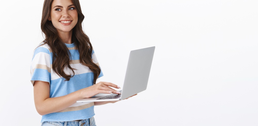 charming-young-woman-working-freelance-remote-from-office-hold-laptop-typing-university-essay-turn-left-smiling-copy-space-joyful-browsing-web-using-computer (1)